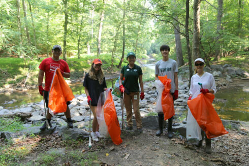 Group photos of volunteers by the stream.