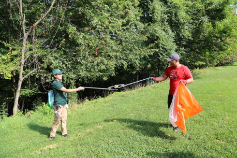 Staff handing litter to a volunteer.