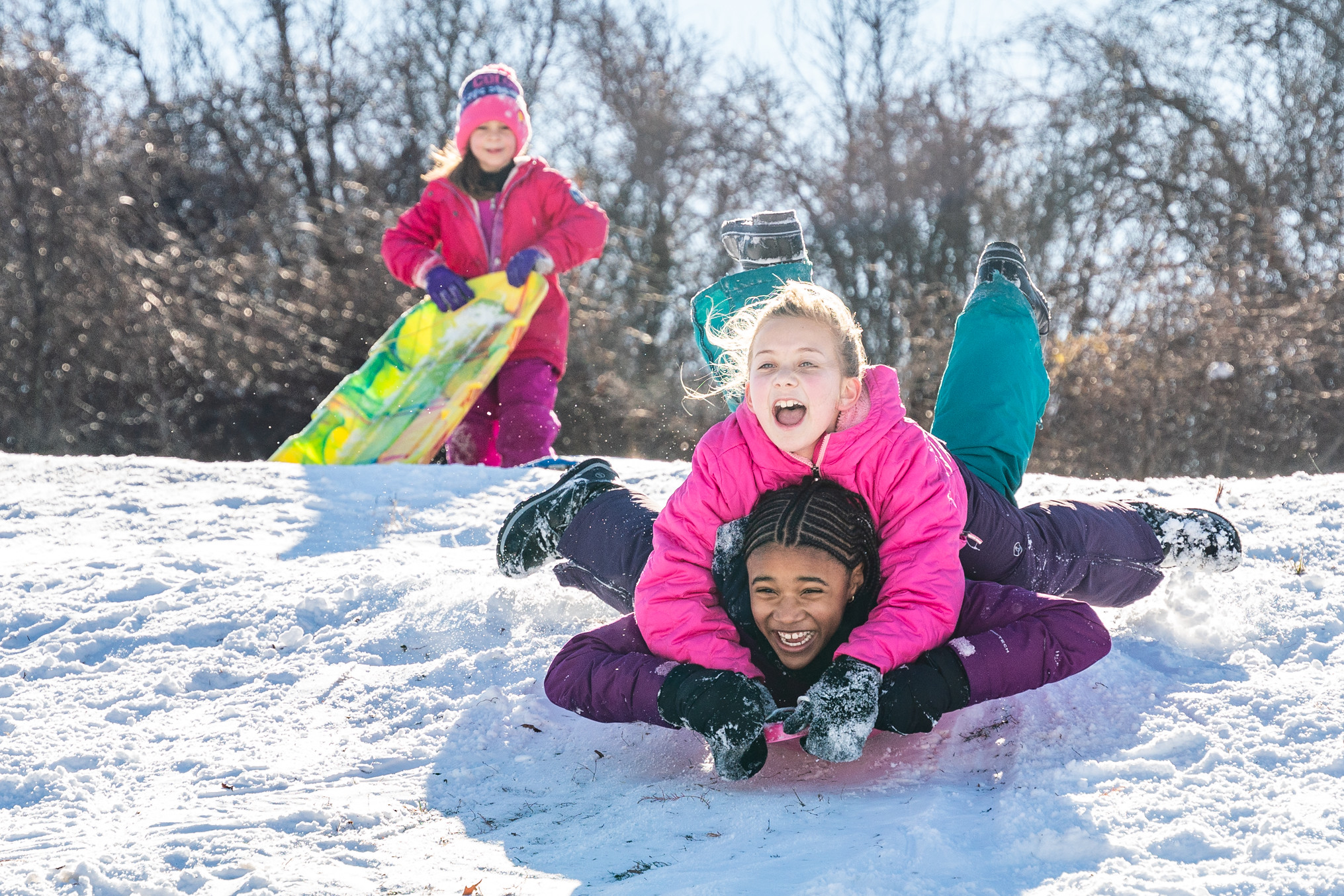 Three youth sledding