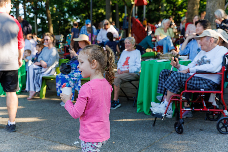 Children and adults enjoying live music at Flower Avenue Urban Park