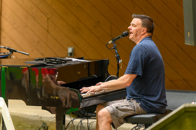 Jimmy Morouse playing piano and singing to audience at Cabin John Regional Park in summer 2023