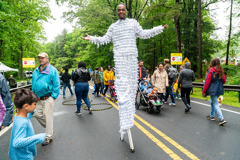 A person walking on stilts wearing a silver costume.