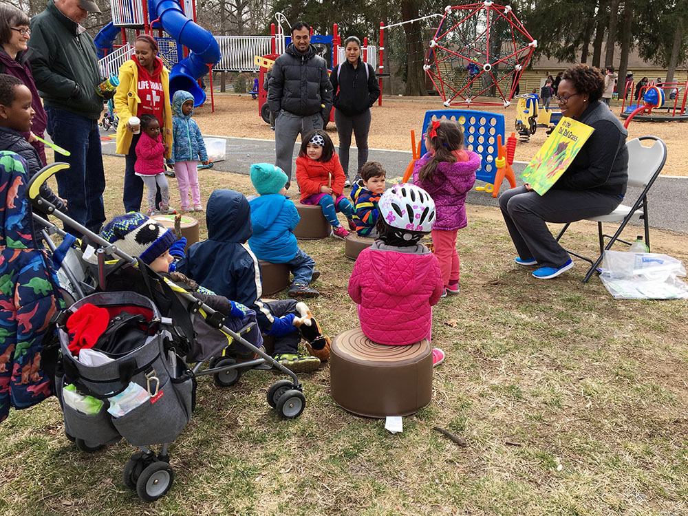 children being read to in the park