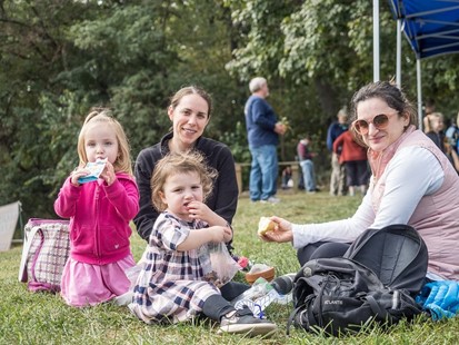 family sitting on the ground having a picnic