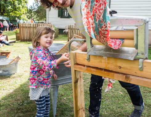 Girl rinsing laundry with antique equipment 