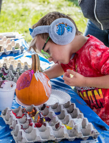 Boy painting pumpkin