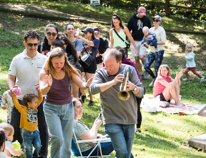 band member start of line dancing with kids and parents at kids from the crowd at Sunday Serenade April 2024 Cabin John Regional Park