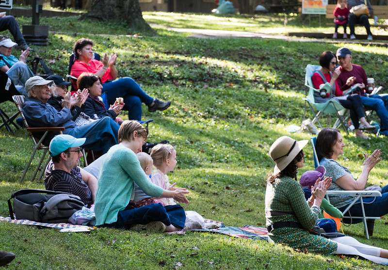 groups of people sitting in the grass enjoying music at Sunday Serenade April 2024 Cabin John Regional Park
