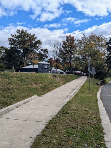 ADA Port-a-John positioned at the top of paved ramp which leads down to trail.