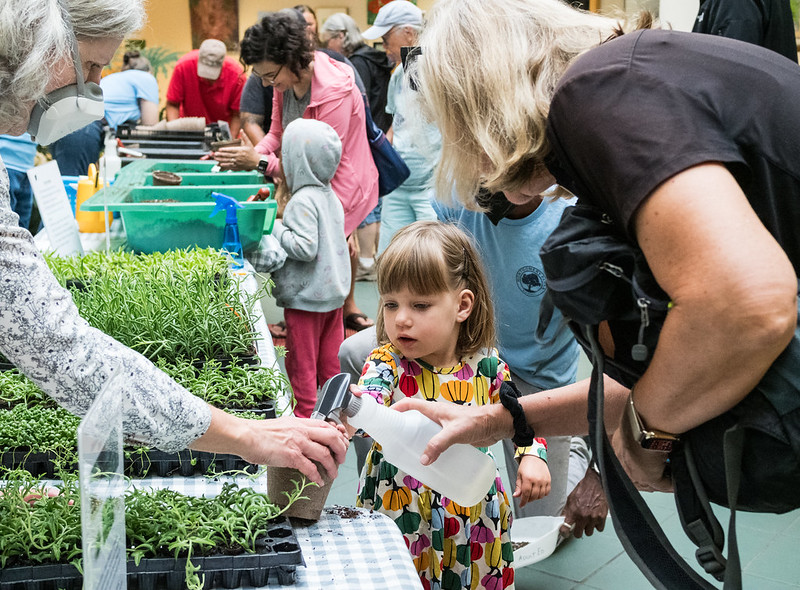 girl watering a plant a Children's Day at Brookside Gardens