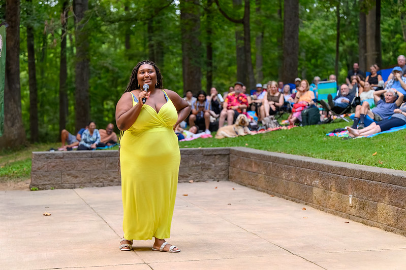 Comedian in yellow dress telling jokes