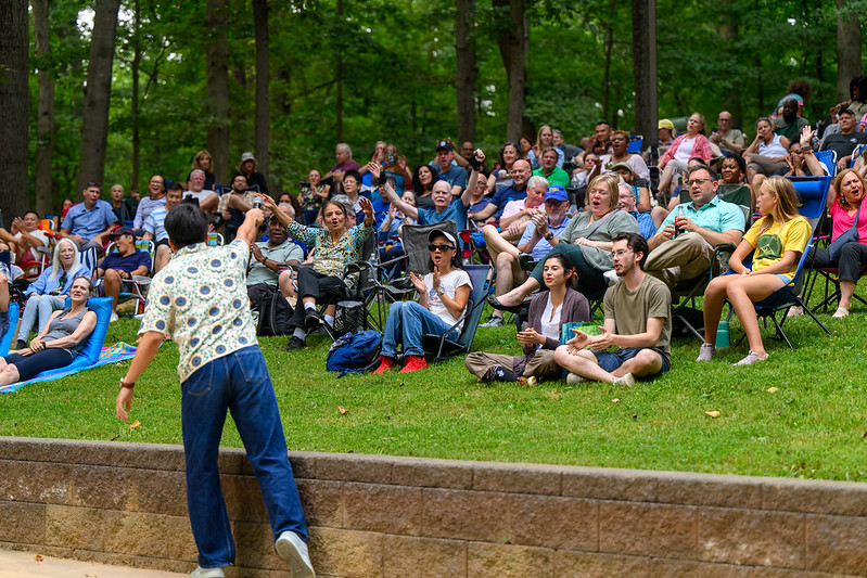 Comedian holding out microphone to crowd