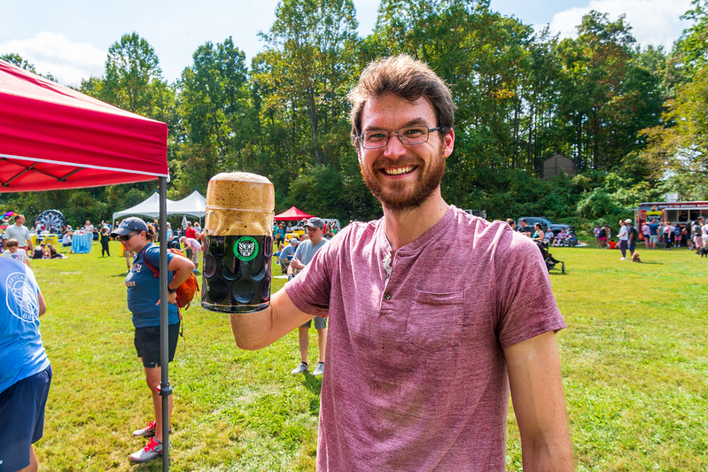 Smiling man holding up glass of beer