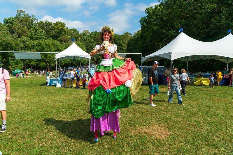 Stilt walker dressed up in German attire smiling