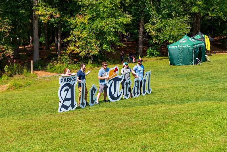 Friends posing with large Ale Trail letters in field