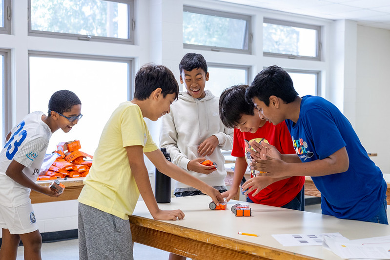 Young kids smiling and playing with robots