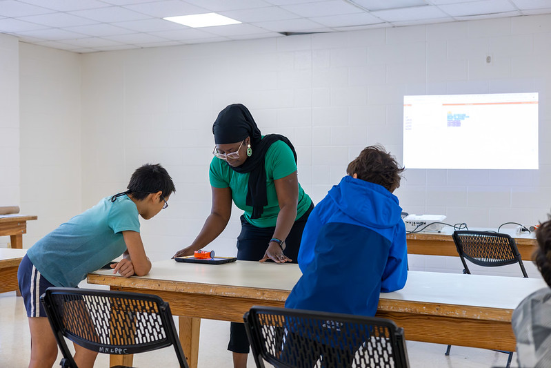 Instructor helps young boys program their robot with an iPad