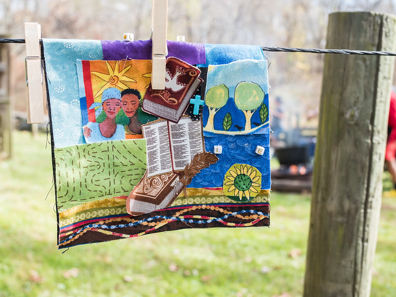 Quilt created to celebrate Maryland Emancipation Day  hanging on wire, held up by clothespin.