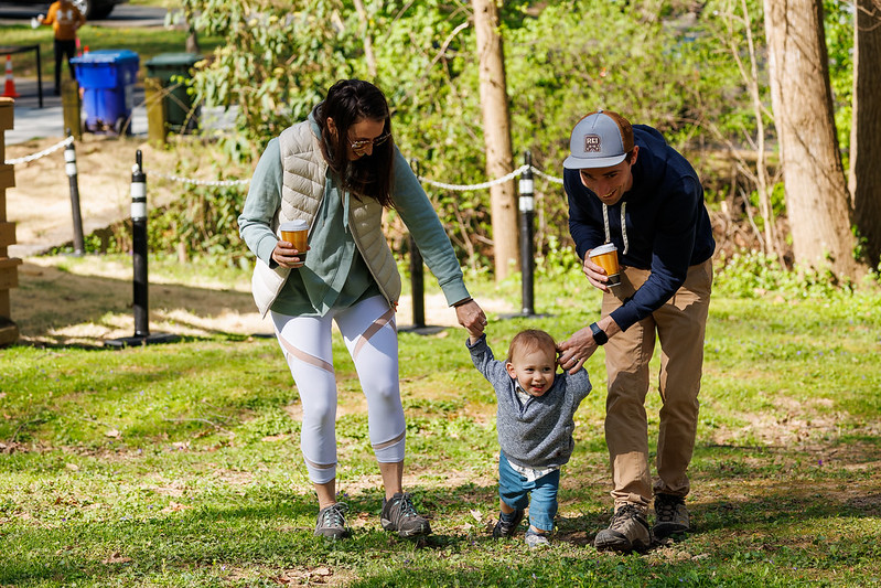 Parents hold their child's hand while walking to event