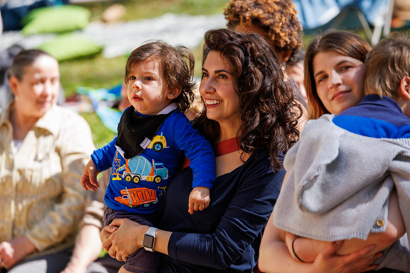 Parent smiling holding child watching performance