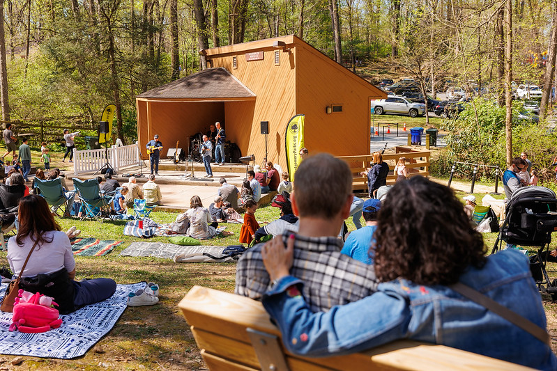 Couple relaxes on bench while band plays in the background