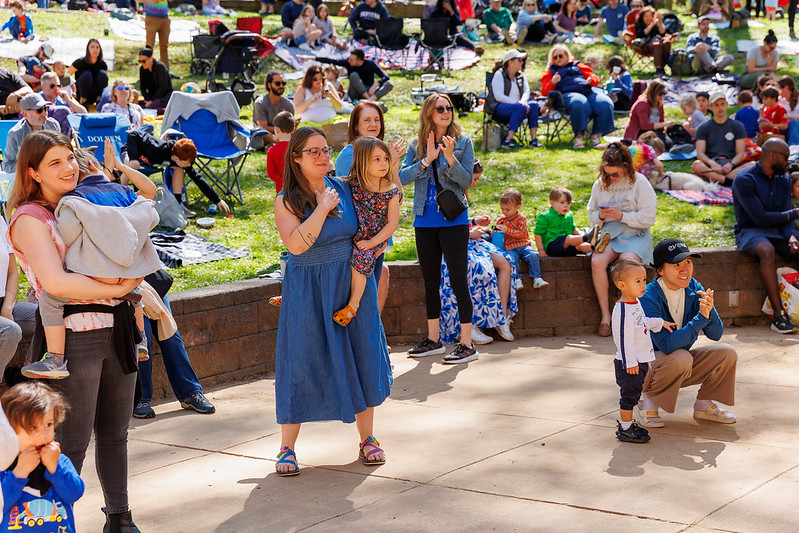 Attendees dance and clap with their children