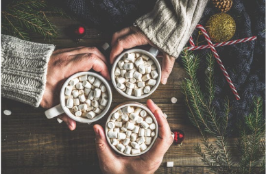 Three hot chocolate mugs with marshmallows are cheering each other.