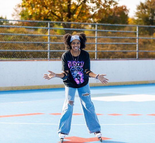 Teen girl poses for camera on roller rink