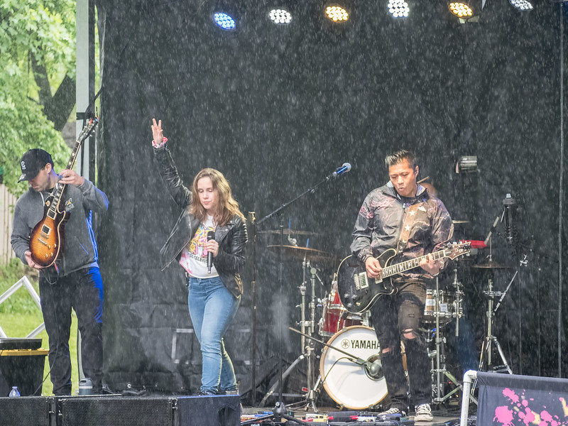 Band plays on stage while rain falls down