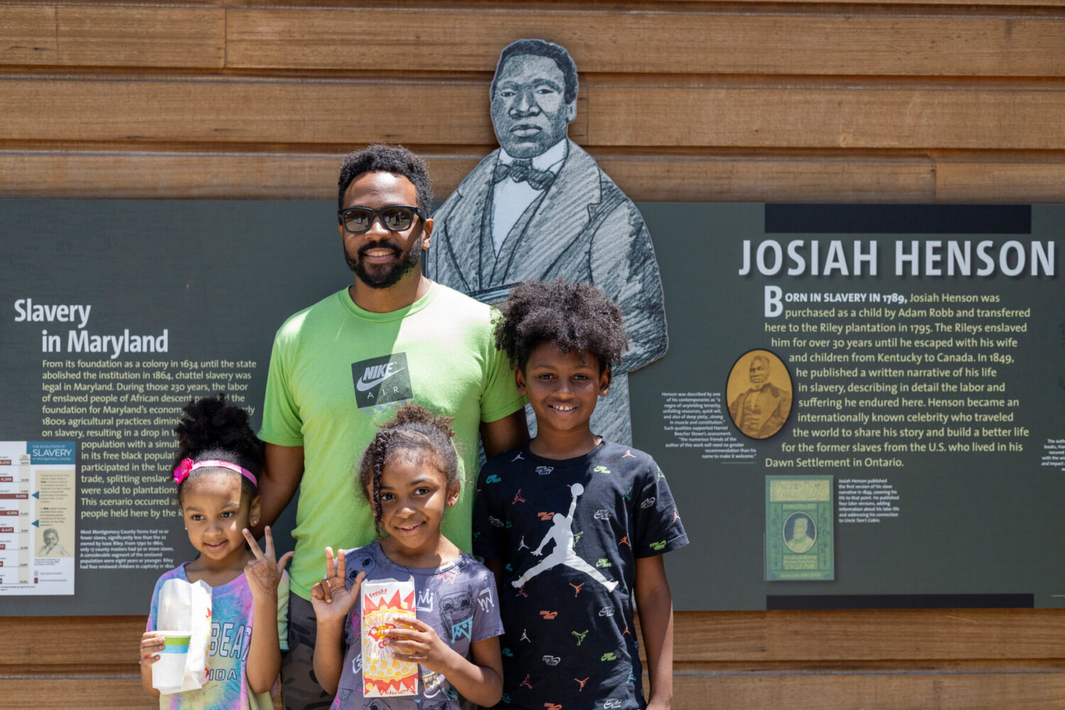 A family poses for a photo outside of Josiah Henson Museum and Park