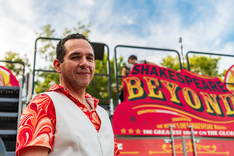 Performer from Chesapeake Shakespeare smiles at camera with stage in background