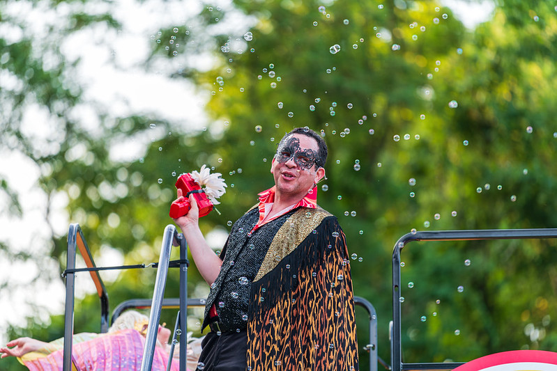 Performer surrounded by bubbles in costume with a mask on