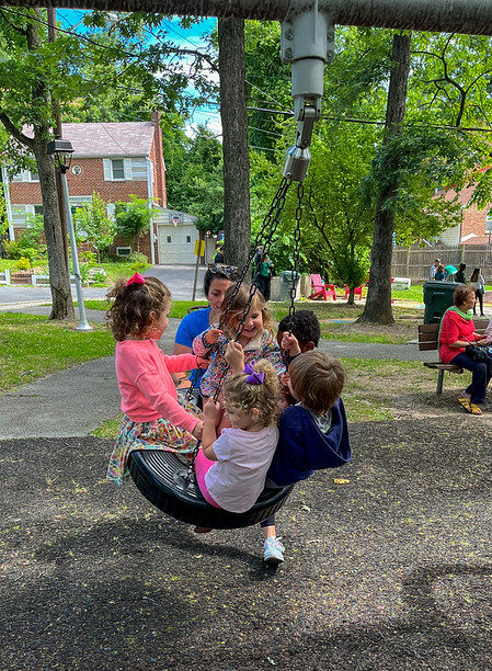 Kids playing on tire swing.