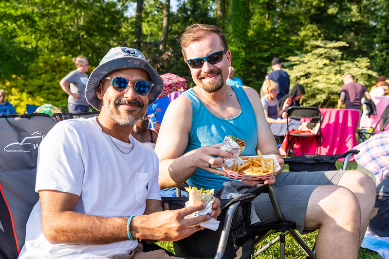 Two-pride-attendees-smile-and-hold-food