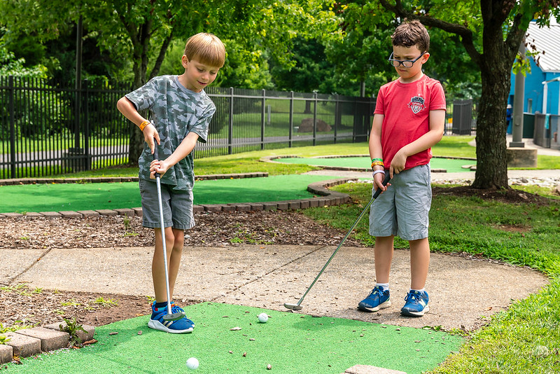 Two boys playing mini golf