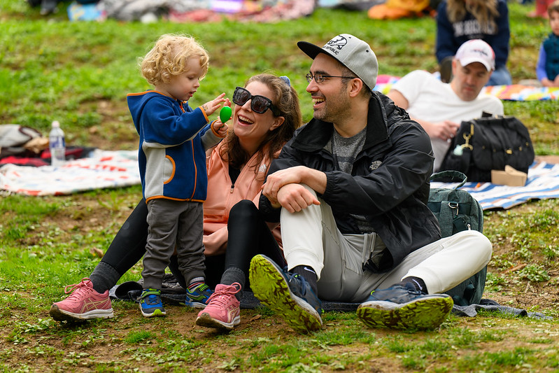 Parents smile happily at young child