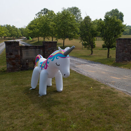 A large blow up unicorn at the entrance of MudFest