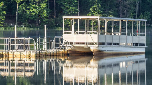 Pontoon boat next to dock on the water at Black Hill