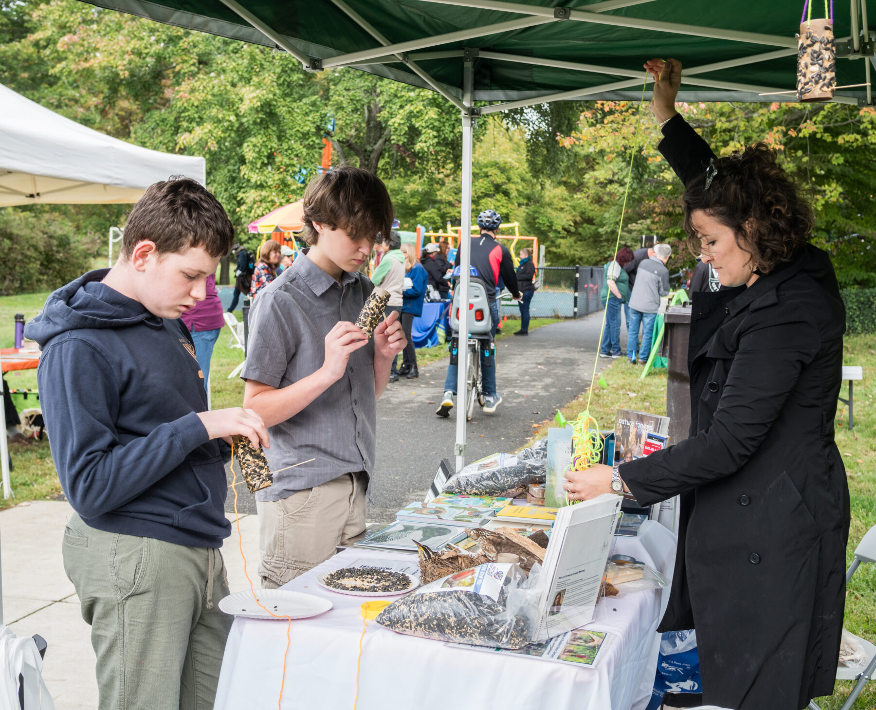 Participants standing in front of a table outside crafting birdfeeders.