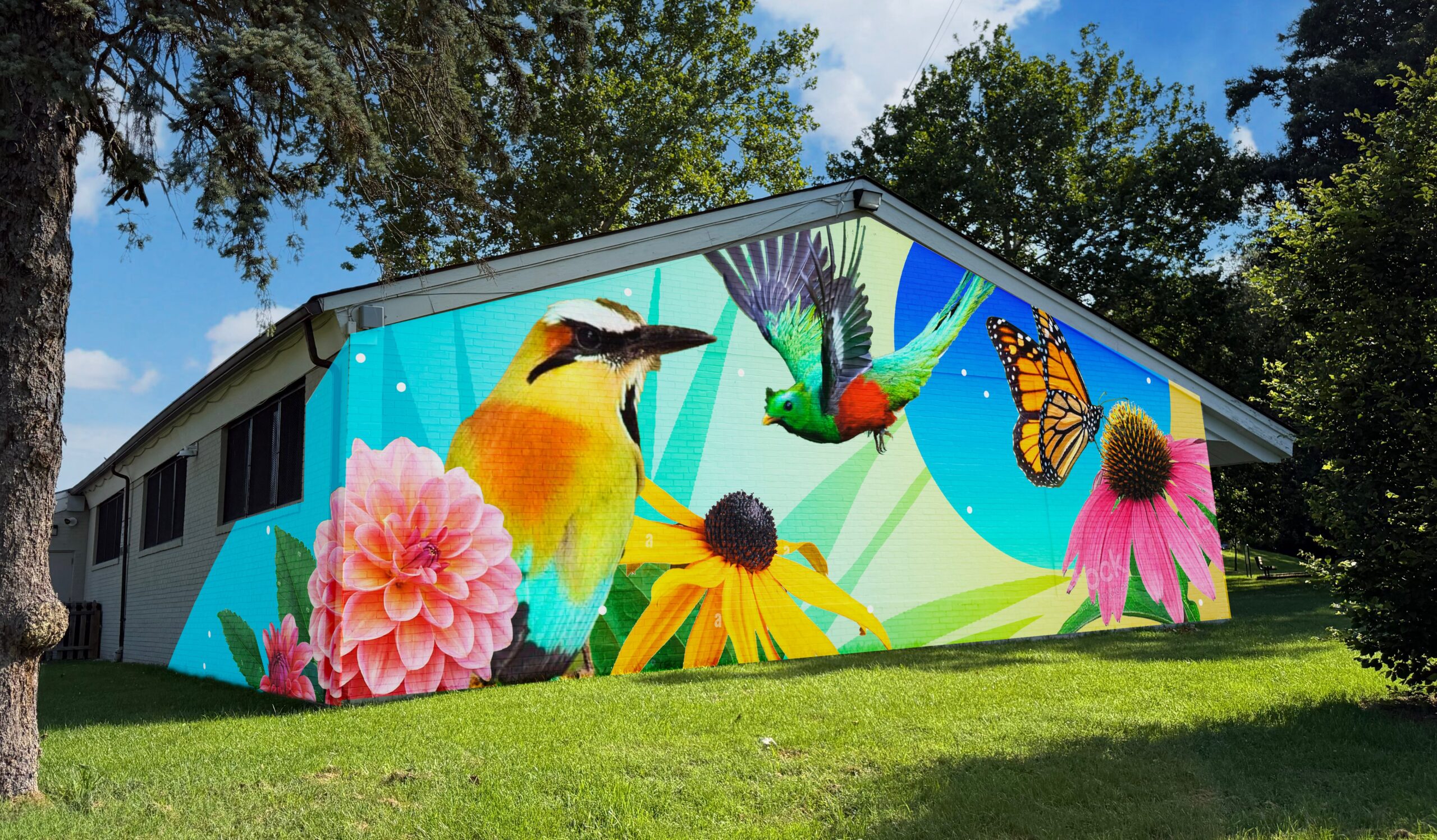 Rendering of the front-facing mural with birds, a butterfly, and flowers, set to a blue and green background