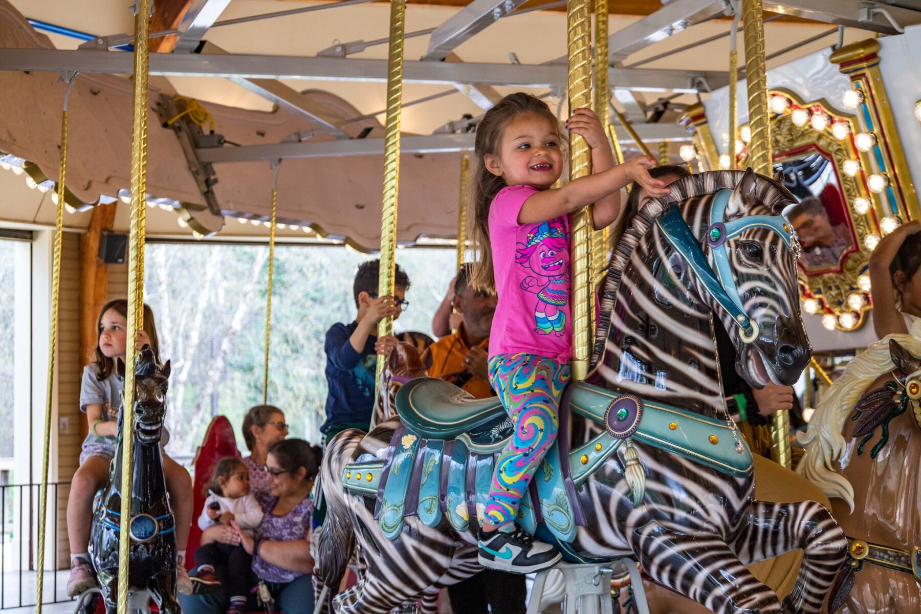 A girl smiling on the carousel