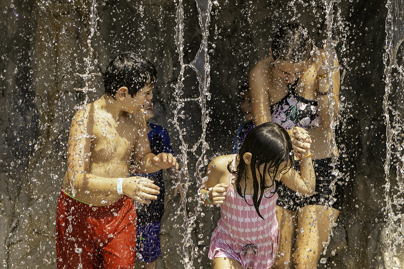 Adult and children tanding in water fountain at South Germantown Splashpark.