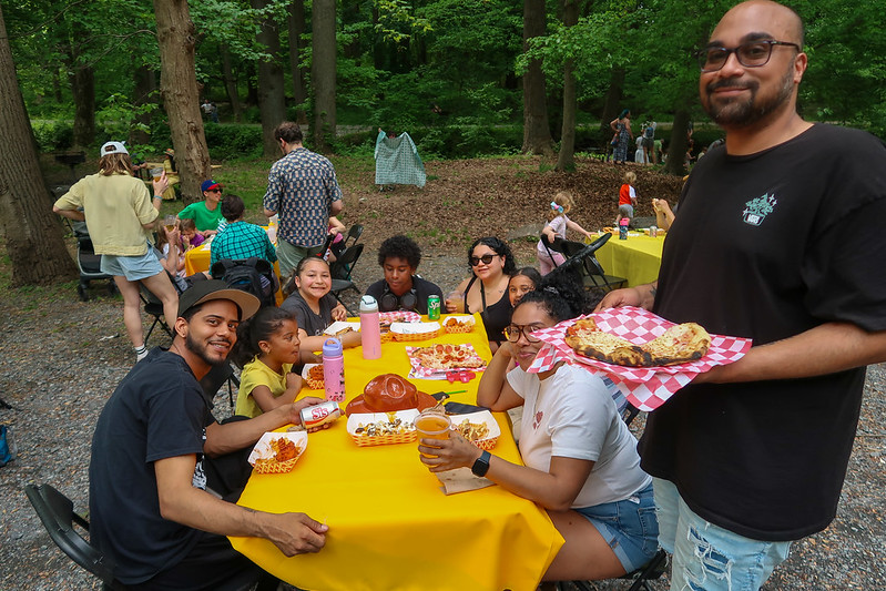 Family smiles for camera at table with food