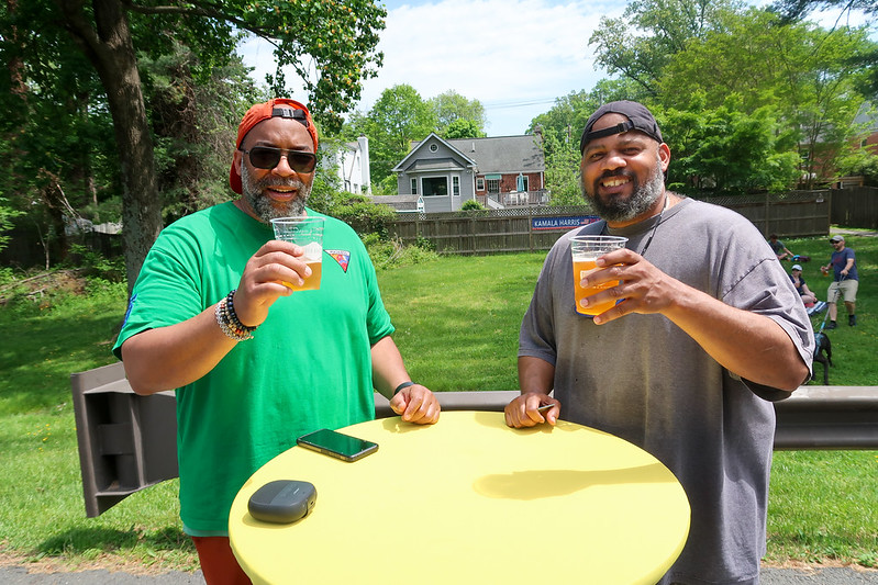 Attendees smile and hold up beer for the camera