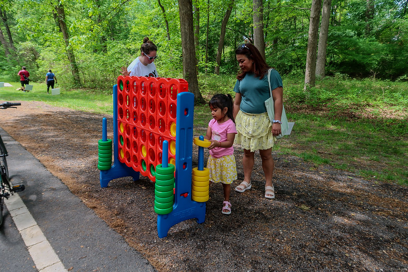 Large connect four game is played by young child and parent