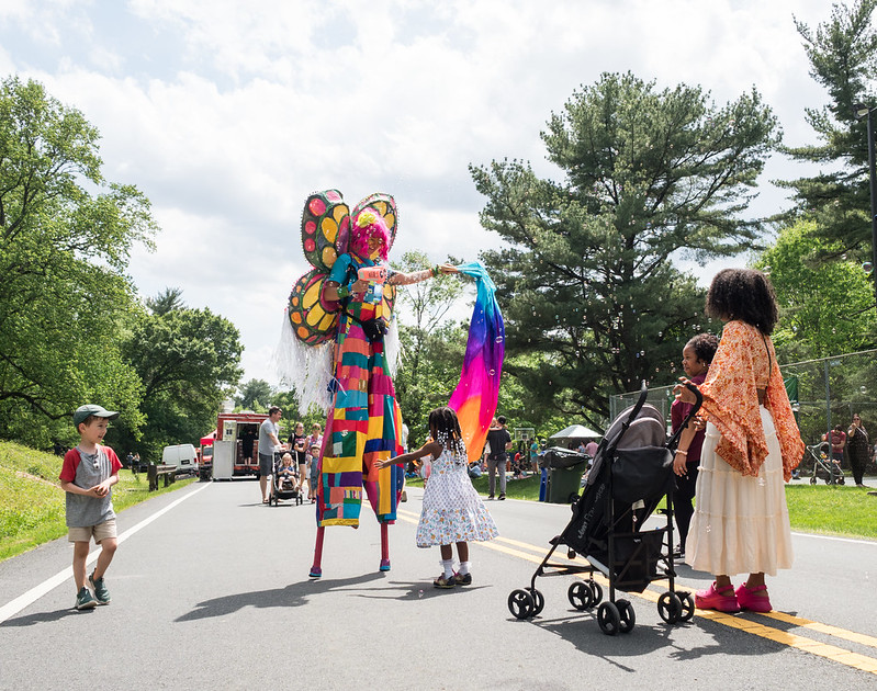 Slit walker wears colorful outfit and shoots bubbles at two children