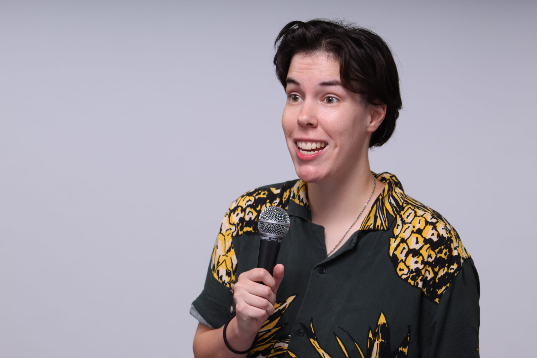 Headshot of comedian Stacey Axler holding a mic