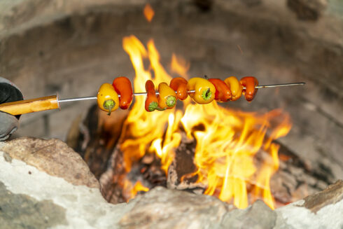 Peppers being roasted over an open fire.
