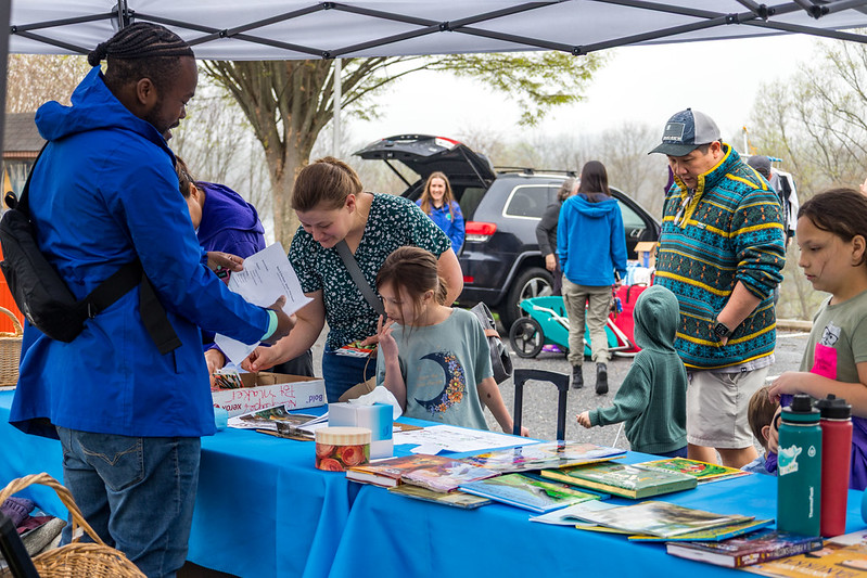 People browsing items on table at Hoilday Share Fair.