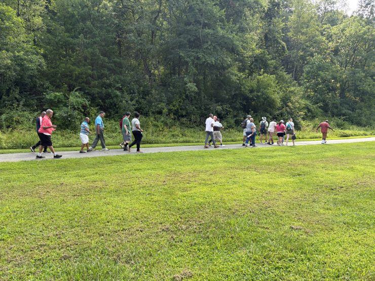 A group of Trail Trekkers walking on a paved trail at Rock Creek Regional Park.